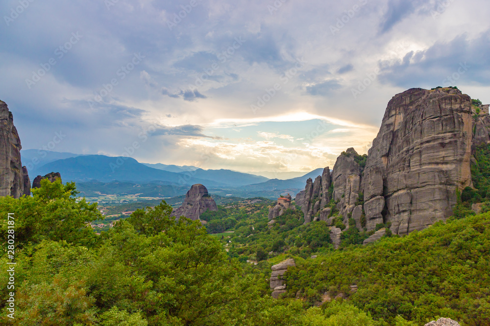 Meteora - incredible sandstone rock formations.  The Meteora area is on UNESCO World Heritage List since 1988. Valley between rocks at sunset. Greece