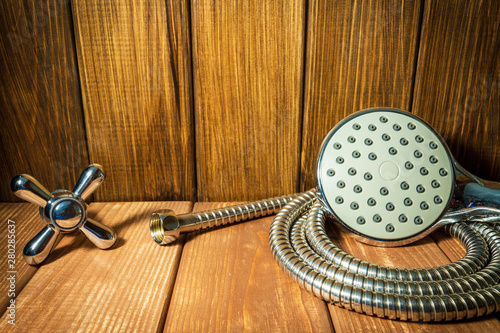 Shower head on vintage wooden background and other plumbing parts.