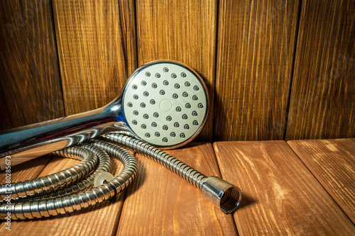 Shower head on vintage wooden background and other plumbing parts.