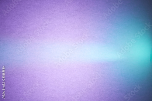 Turquoise ray of light cuts through the textural purple and blue blurred background