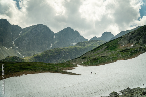 Group of hikers crossing snow in High Tatras