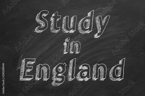 Hand drawing "Study in England" on black chalkboard