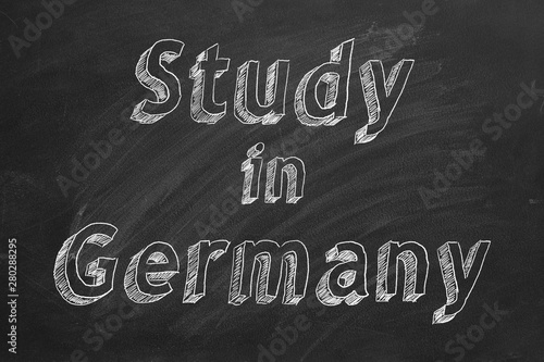 Hand drawing "Study in Germany" on black chalkboard. 