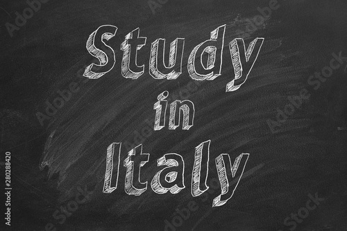 Hand drawing "Study in Italy" on black chalkboard.