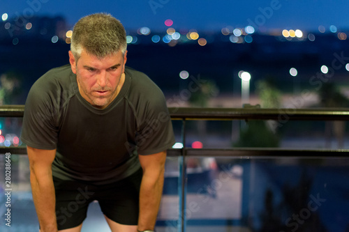 An exhausted man rests after running
