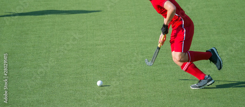 Hockey player with ball in attack playing field hockey game
