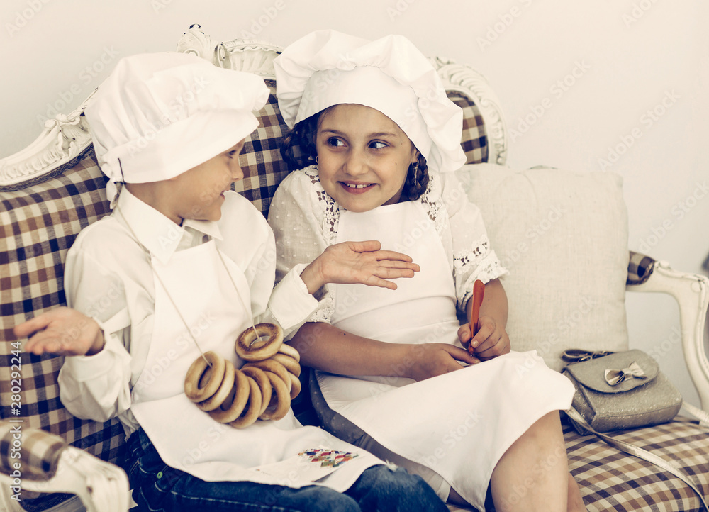 Portrait of happy brother and sister as a chef discussing recipe Portrait of happy brother and sister as a chef discussing recipe
