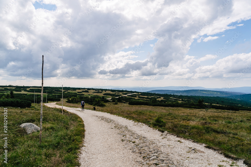 Young woman on the trail in Giant Mountains (Karkonosze), authentic travel experience. 