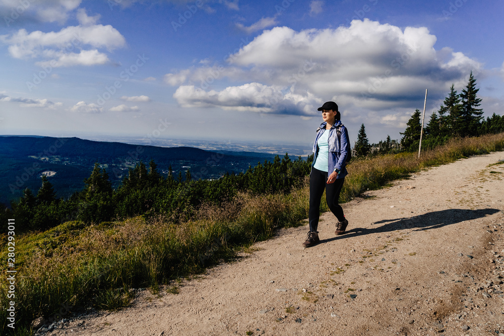 Young woman on the trail in Giant Mountains (Karkonosze), authentic travel experience. 