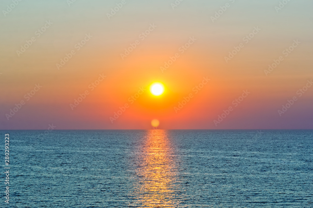 Scenic orange sunset and sun path in the blue sea