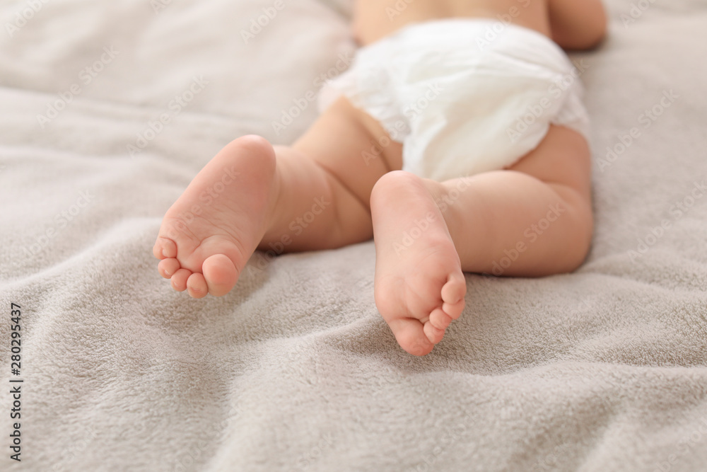 Cute little baby lying on bed, closeup of legs Cute little baby lying on bed, closeup of legs