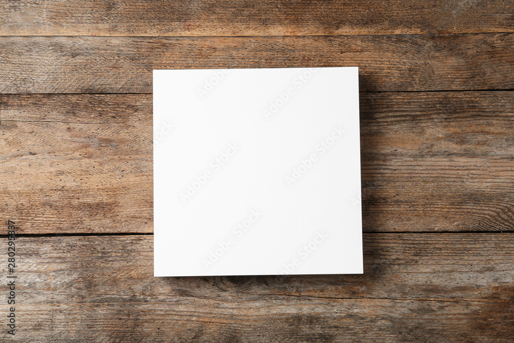 Stack of blank paper sheets for brochure on wooden background, top view. Mock up Stack of blank paper sheets for brochure on wooden background, top view. Mock up