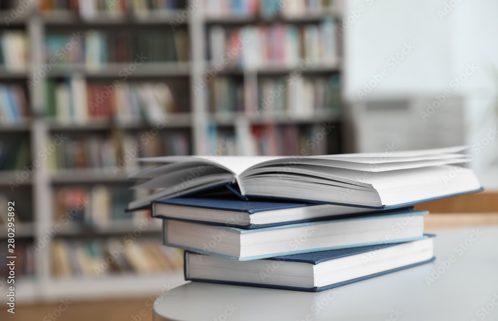 Stack of books on white table in library Stack of books on white table in library