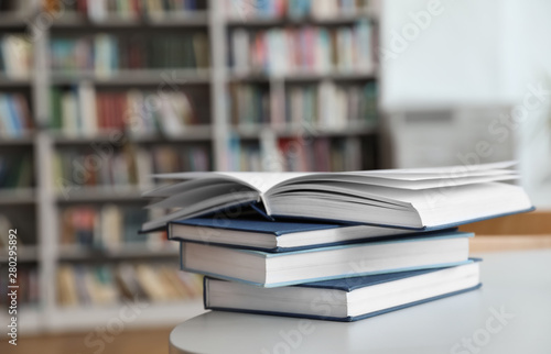 Stack of books on white table in library