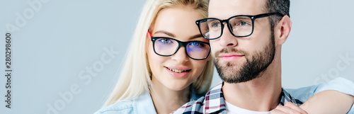 panoramic shot of man and beautiful girl in glasses isolated on grey photo