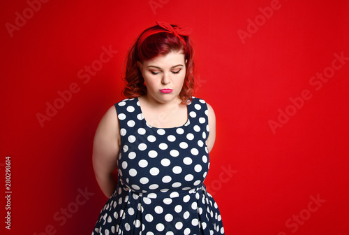 Canvas Print Beautiful woman pinup style portrait in retro dress and makeup, manicure nails hands, red lipstick and polka dot dress