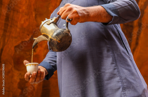 Canvas-taulu bedouin man pouring traditional local coffee into a cup from his kettle