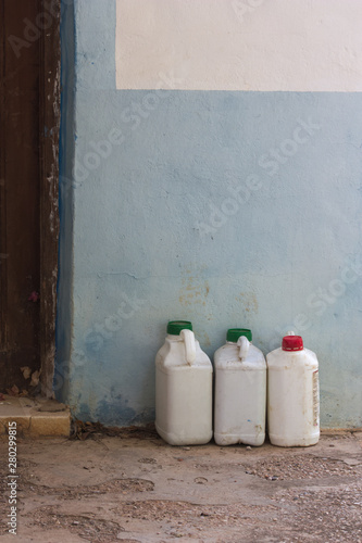 Old white bottles of insecticide next to a wall