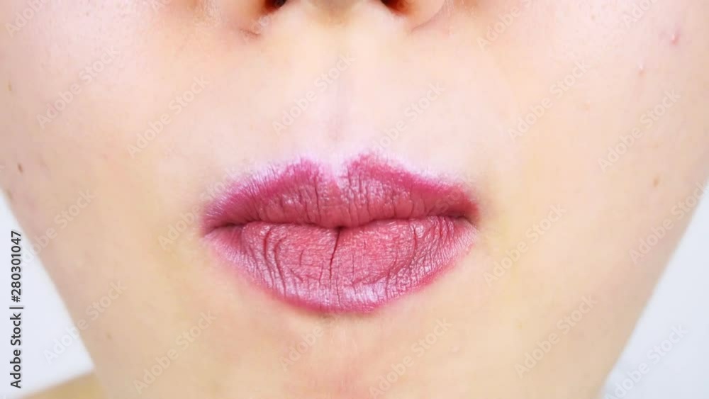 Extreme close-up of lips of a young woman. Woman eating a slice of dark chocolate with filling. Women's morning makeup Extreme close-up of lips of a young woman. Woman eating a slice of dark chocolate with filling. Women's morning makeup