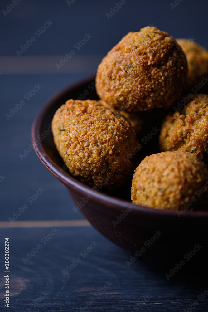 Classic hummus balls in a clay plate on a wooden table. National, vegetarian dish. General form. Classic hummus balls in a clay plate on a wooden table. National, vegetarian dish. General form.