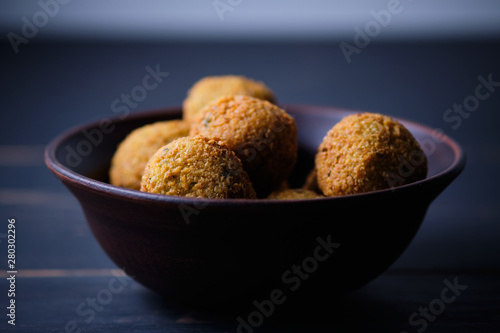 Classic hummus balls in a clay plate on a wooden table. National, vegetarian dish. General form.