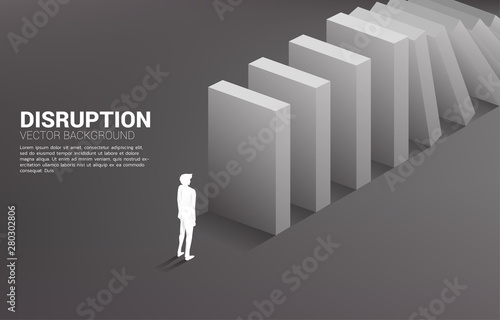 Silhouette of businessman standing at the end of domino collapse. Concept of business industry disrupt