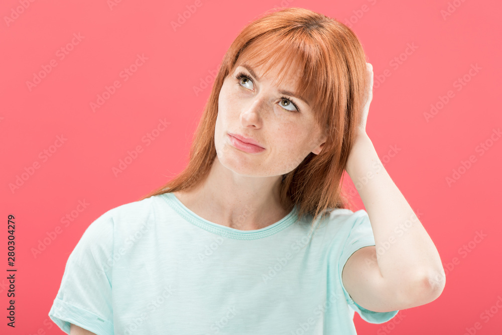 pensive redhead young woman looking away and touching hair isolated on pink pensive redhead young woman looking away and touching hair isolated on pink