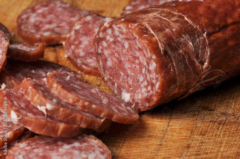 Sausage on a wooden board isolated on a white background.Food Sausage on a wooden board isolated on a white background.Food