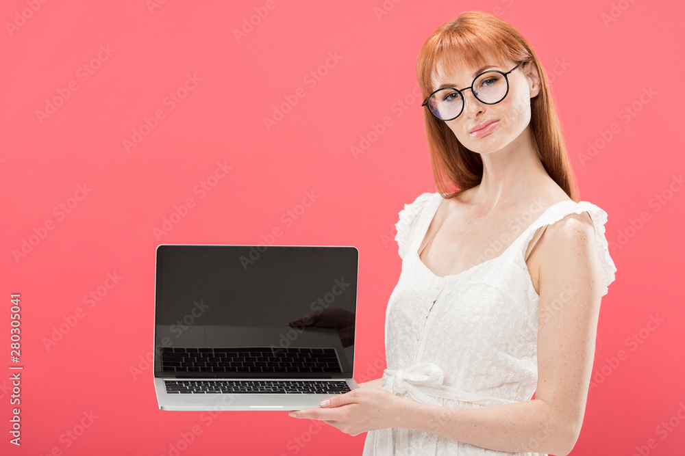 redhead young woman in glasses holding laptop with blank screen isolated on pink redhead young woman in glasses holding laptop with blank screen isolated on pink