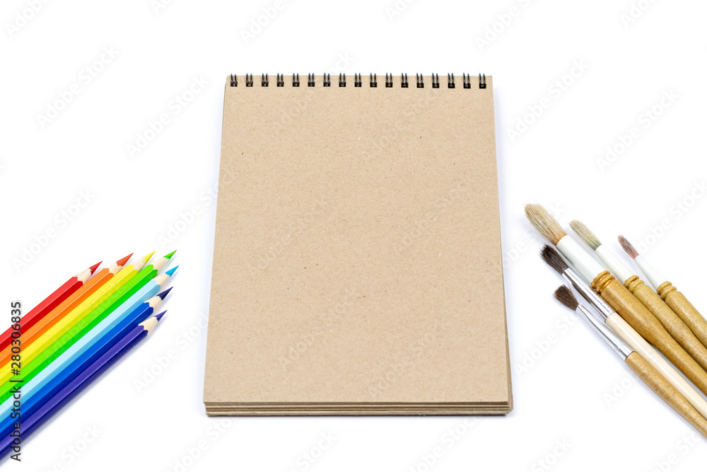 Coloured pencils, Watercolour brushes, notebook isolated on white background for mockup. Flat lay, top view. Concept: Back to school. Coloured pencils, Watercolour brushes, notebook isolated on white background for mockup. Flat lay, top view. Concept: Back to school.