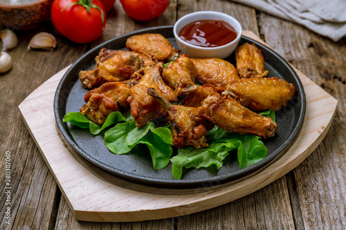 chicken wings in barbecue sauce on wooden background