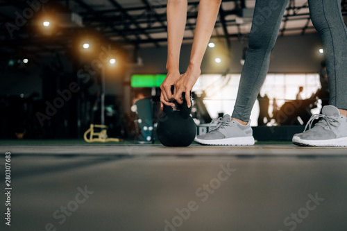 sport woman at fitness gym club doing exercise for arms with kettlebell and showing muscle bodybuilding, fitness concept, sport concept © I Believe I Can Fly