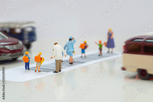 Miniature toys school kids walk on cross road bar code with traffic stopped concept