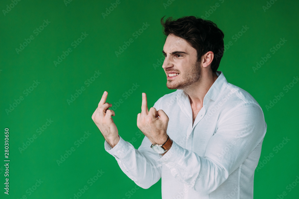 angry man in white shirt showing middle fingers isolated on green angry man in white shirt showing middle fingers isolated on green