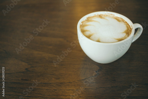 Coffee cup and coffee beans on wooden table in cafe