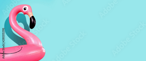 Giant inflatable Flamingo on a blue background, pool float party, trendy summer concept, banner background with copy space