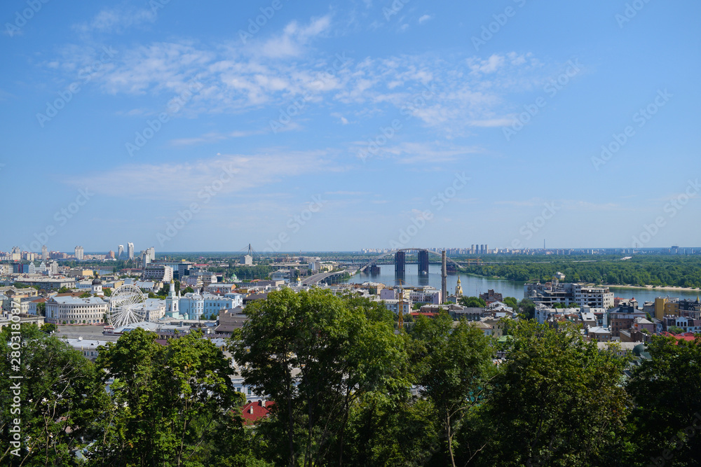 View through the green foliage of the city from above. Panorama.