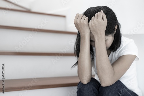 The depression woman alone sitting on staircase she thought so much and headaches, eye pain. photo