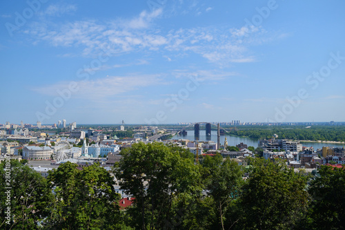 View through the green foliage of the city from above. Panorama.