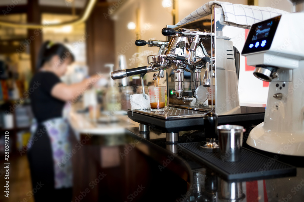Close-up of Coffee machine Barista woman making coffee on the background blurry. Close-up of Coffee machine Barista woman making coffee on the background blurry.