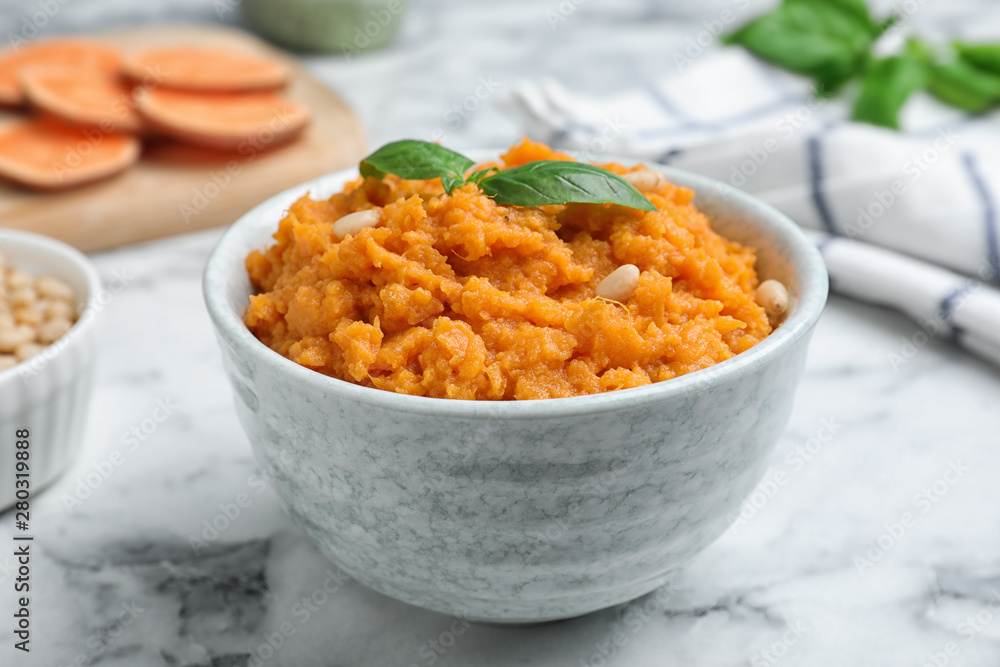 Bowl of tasty sweet potato puree on marble table Bowl of tasty sweet potato puree on marble table