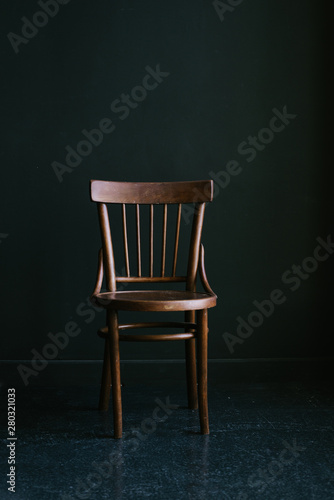 Old-fashioned wooden chair on a dark background in the interior photo