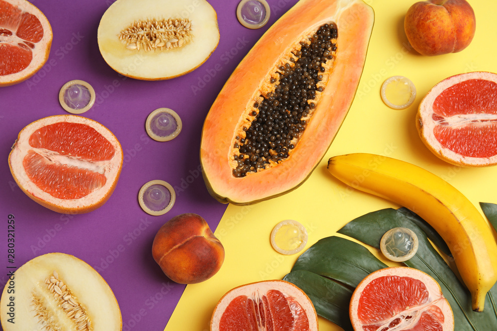 Flat lay composition with condoms and exotic fruits on color background. Erotic concept