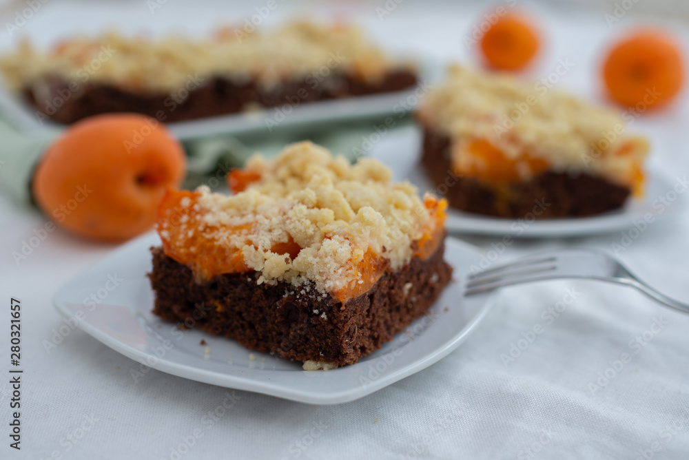 Delicious home made chocolate apricot cake with sweet streusel on a table Delicious home made chocolate apricot cake with sweet streusel on a table