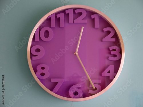 Purple wall clock on blue background