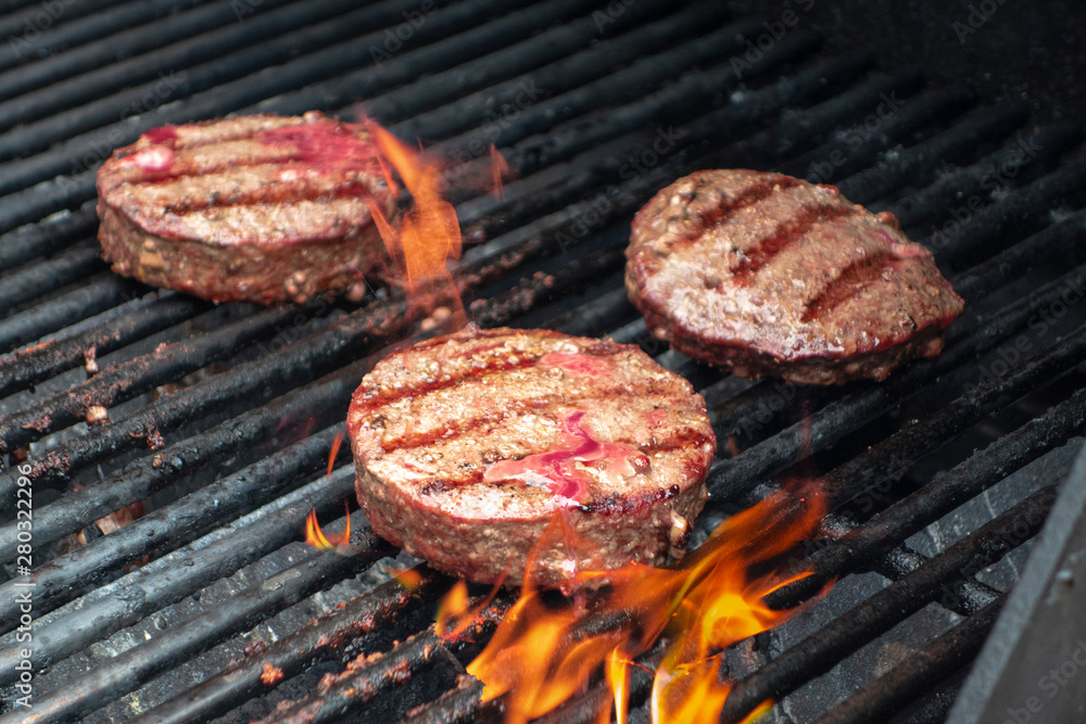 summer close up beef hamburger BBQ on a propane gas grill