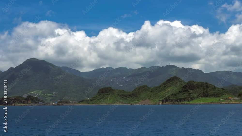 Beautiful timelapse of green mountain and clouds in the tropical island of Taiwan. Beauty landscape with ocean and blue sky at Keelung. Scenic waterfront at sunny day of summer.-Dan Beautiful timelapse of green mountain and clouds in the tropical island of Taiwan. Beauty landscape with ocean and blue sky at Keelung. Scenic waterfront at sunny day of summer.-Dan