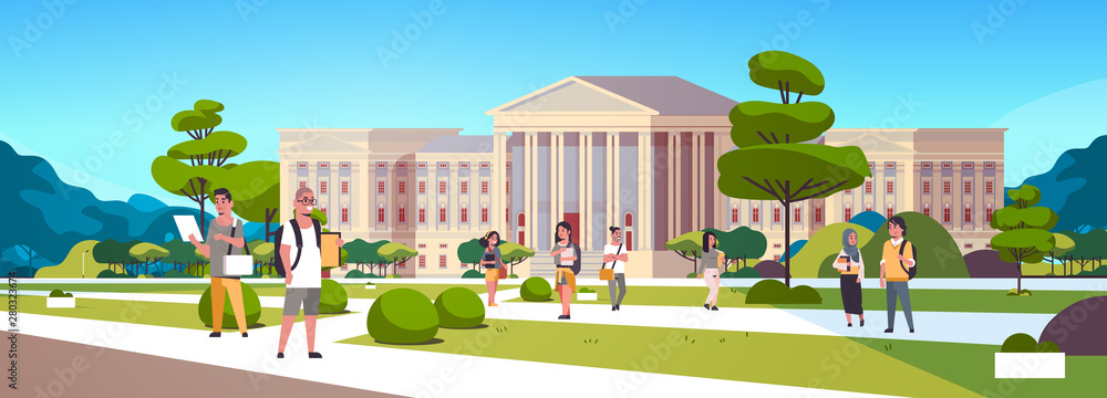 young mix race students group at campus yard education concept college friends relaxing and walking in front of university building exterior horizontal full length