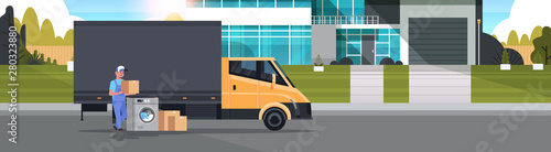 courier man near delivery truck with cardboard boxes washing machine domestic appliances store goods purchase distribution concept cottage house exterior full length horizontal