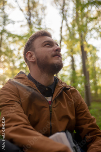 one young man, looking above, low angle shot, in forest.